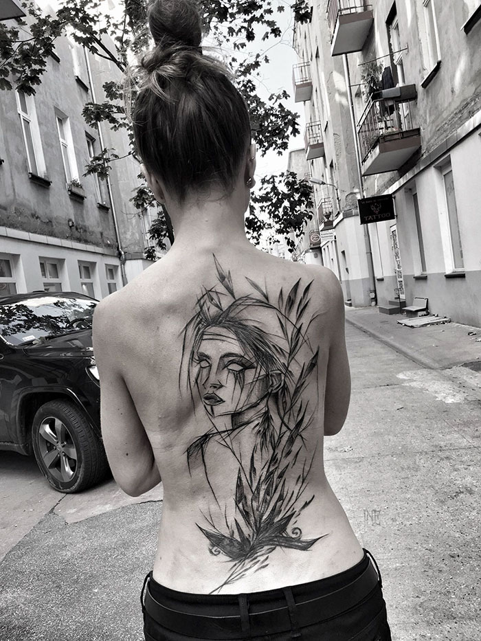 A woman with a large sketch tattoo on her back, showcasing the beauty of imperfection by a Polish tattoo artist.