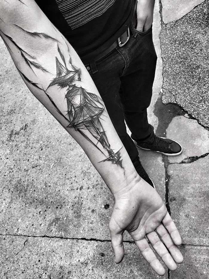 Forearm with sketch tattoo art by Polish tattoo artist, showcasing beauty in imperfection in a monochromatic design.