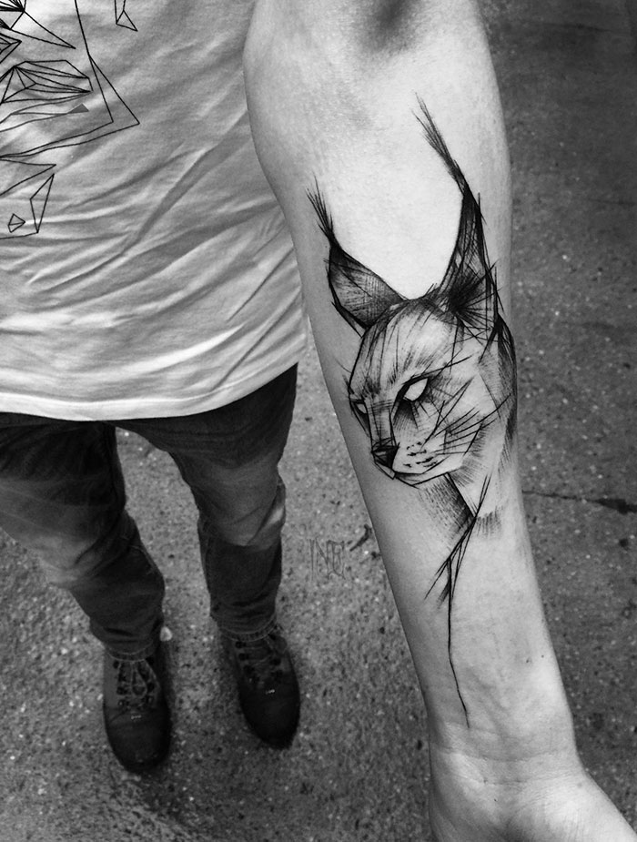 Sketch tattoo of a lynx on an arm, showcasing the beauty of imperfection by Polish tattoo artist.