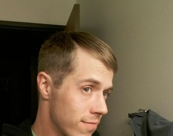 Young man taking a side selfie indoors, showing clear skin and healthy appearance after stopping drinking.