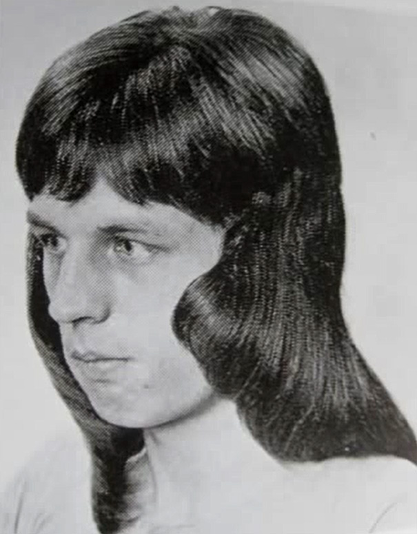 Vintage men's hairstyle with long, wavy locks typical of 1960s and 1970s romantic trends.