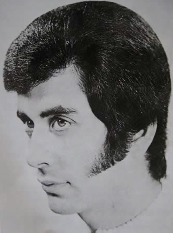 Man with classic 1960s hairstyle featuring thick sideburns and voluminous hair.