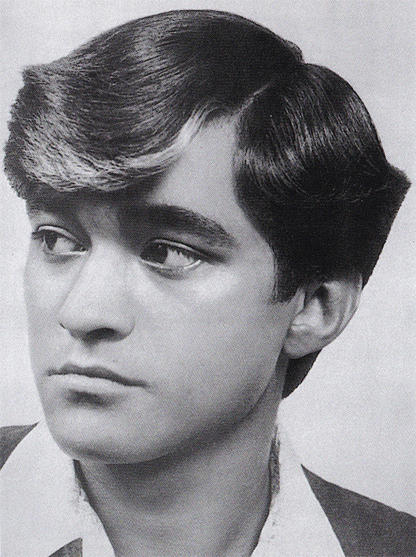 Man with classic 1960s hairstyle, featuring slicked back hair and side part, embodying romantic men's fashion of the era.