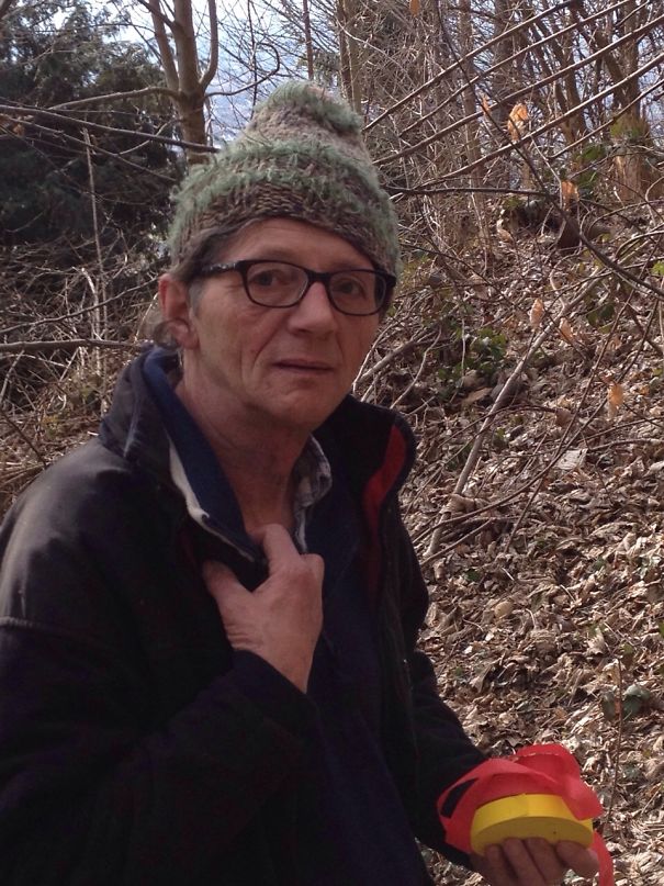 Man wearing glasses and a knit hat outdoors holding red and yellow objects, illustrating before and after quitting drinking effects