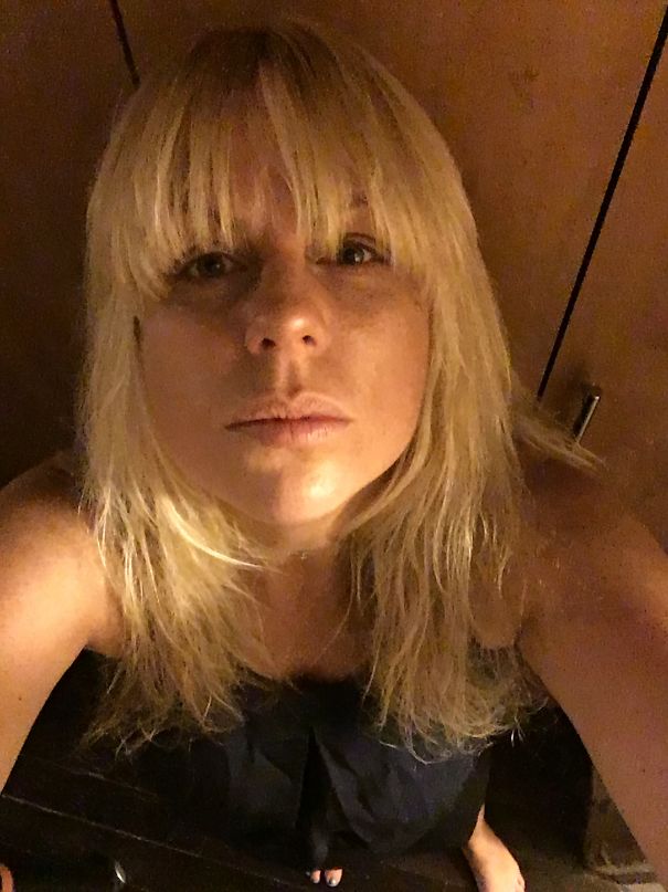 Woman with blonde hair looking up at the camera, showing visible effects of stopping drinking in before-and-after pics.