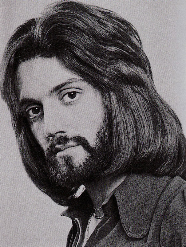 Vintage photo of a man from the 1970s with long hair and beard, exemplifying romantic men's hairstyles of the era.