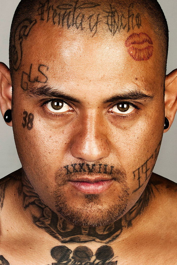 Ex-gang member with visible facial tattoos, looking directly at the camera. Ex-gang member with visible facial tattoos, looking directly at the camera.