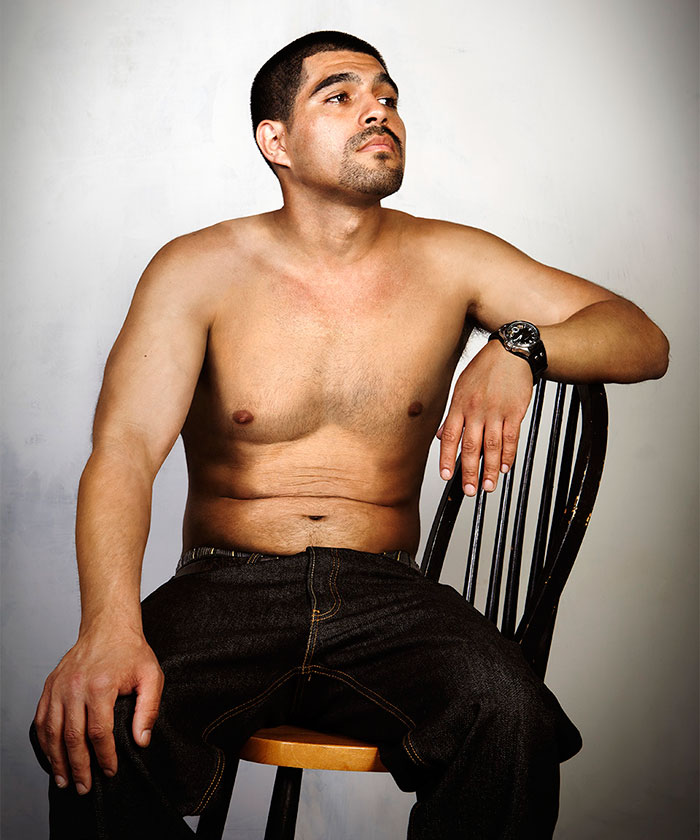 Shirtless ex-gang member sitting on a chair, highlighting tattoo removal transformation. Shirtless ex-gang member sitting on a chair, highlighting tattoo removal transformation.