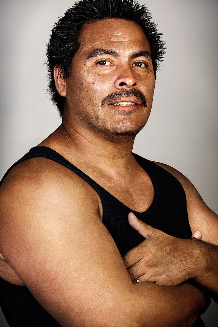 Ex-gang member in a black tank top with tattoos removed, confidently looking ahead. Ex-gang member in a black tank top with tattoos removed, confidently looking ahead.