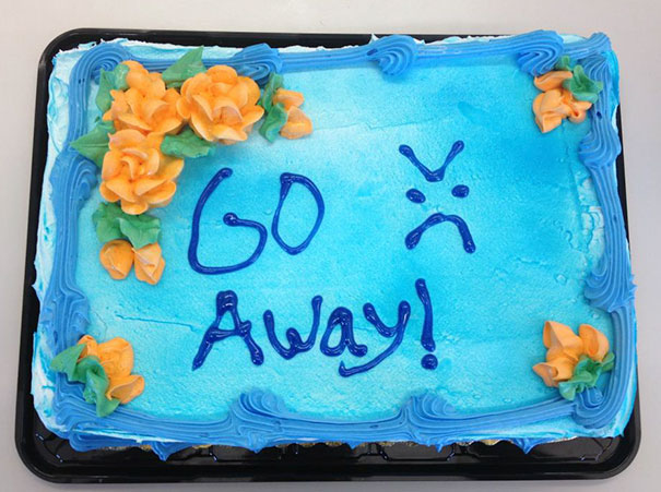 Farewell cake with blue icing, "Go Away!" message, and orange flowers, part of a humorous office farewell.