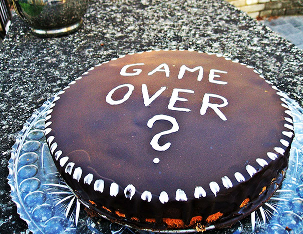 Farewell cake with "Game Over?" written on top, humorously marking an employee's last day at the office.