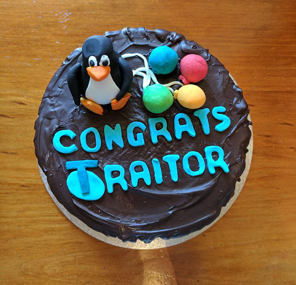 Farewell cake with "Congrats Traitor" message, decorated with a penguin and colorful fondant balloons.