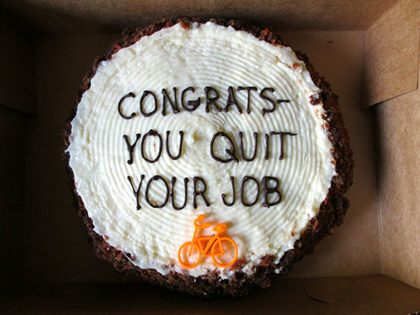 Farewell cake with "Congrats-You Quit Your Job" message and a small orange bicycle decoration.