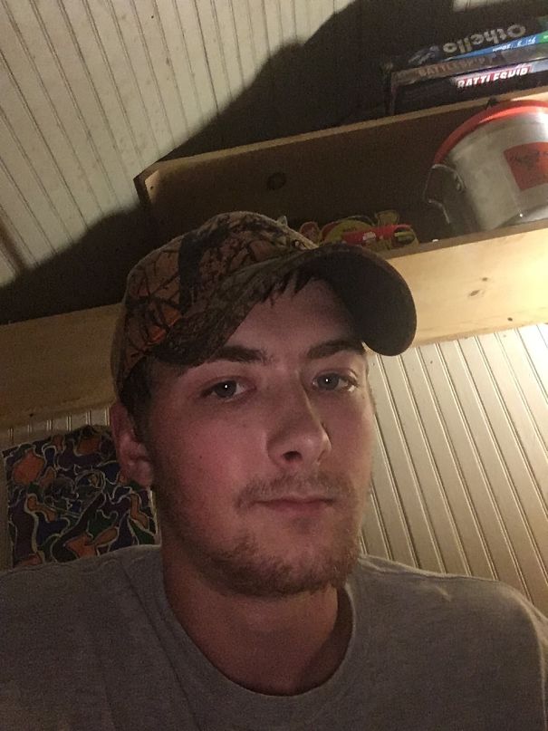 Young man wearing a camouflage cap and gray shirt indoors, showing a clear complexion in before and after pics of quitting drinking