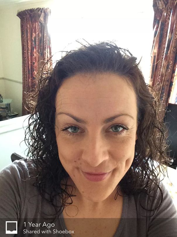 Close-up of a woman smiling with curly hair showing a healthy glow in before-and-after pics of stopping drinking.