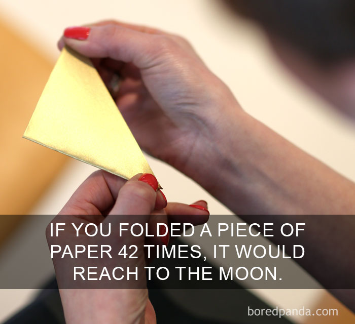 Hands folding paper with text about an amazing fact involving paper folding reaching the moon distance.
