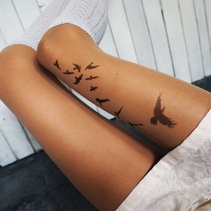 Tattoo tights with bird design creating illusion of leg ink.