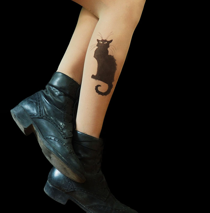 Tattoo tights featuring a black cat design, creating an illusion of inked legs, paired with black boots.