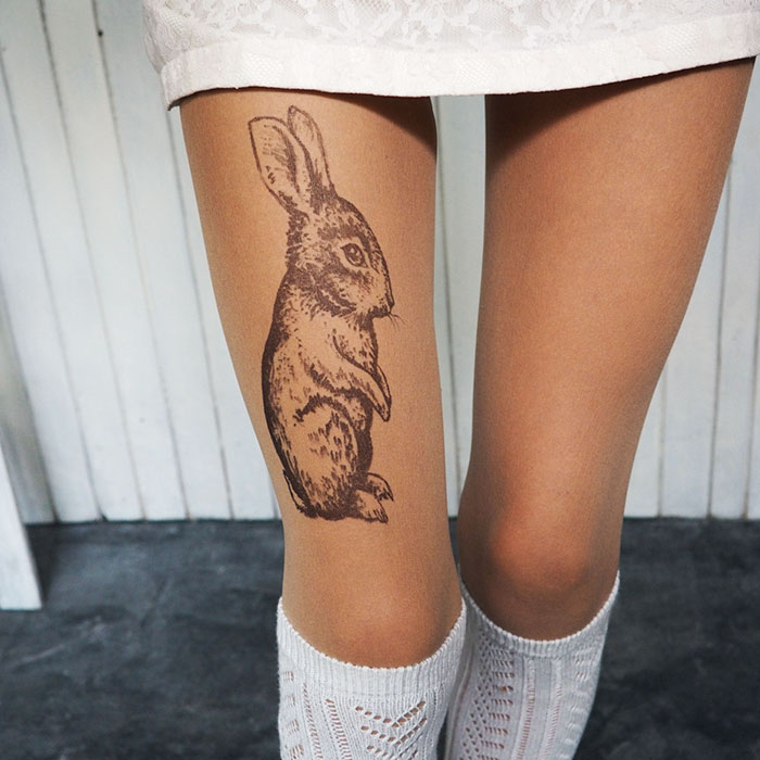 Tattoo tights with a rabbit design creating an illusion of inked legs, worn with white knitted socks.