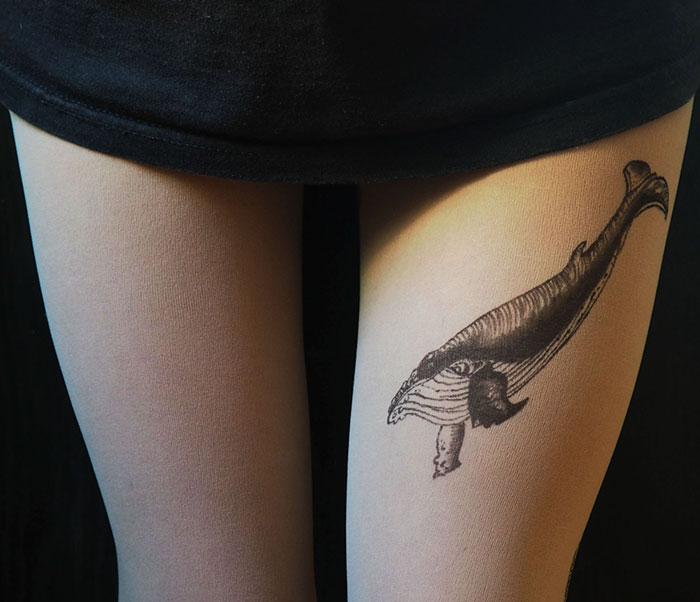 Tattoo tights with a whale design, creating an inked illusion on legs, worn with a black skirt.