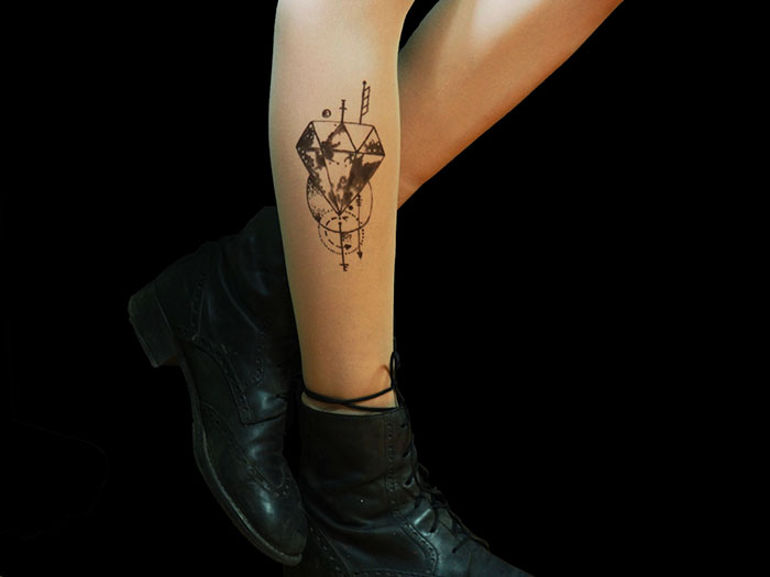 Tattoo tights creating an illusion of inked legs, featuring geometric designs, worn with black boots.