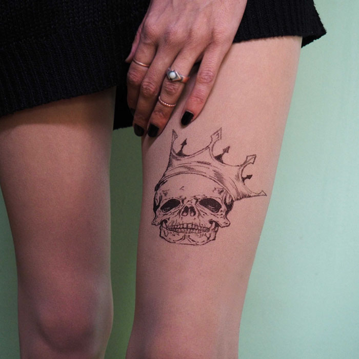 Tattoo tights featuring a skull with a crown design, creating the illusion of inked legs.