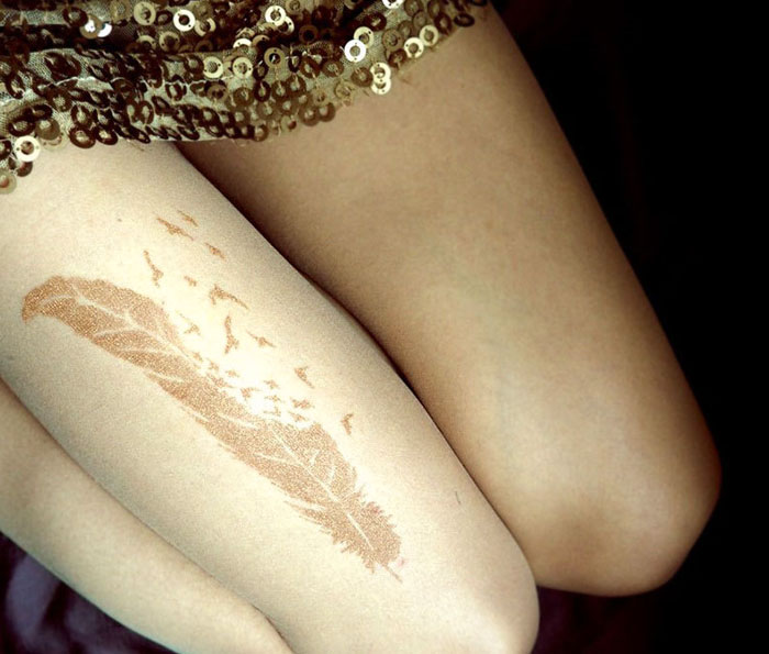 Tattoo tights with feather design create a leg-inked illusion, worn with a sequined skirt.