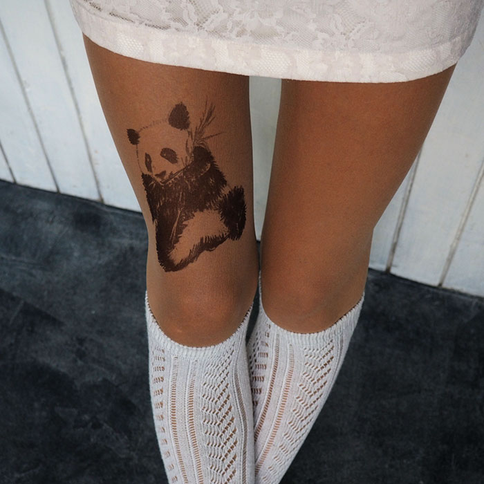 Tattoo tights with a panda design creating an illusion of inked legs, paired with white knit socks.