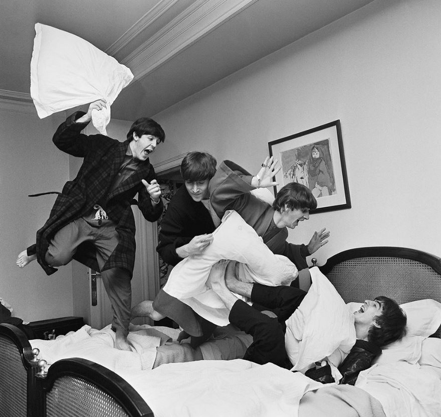 Iconic photo of four men having a pillow fight in a hotel room, showcasing a fun and candid moment in history.