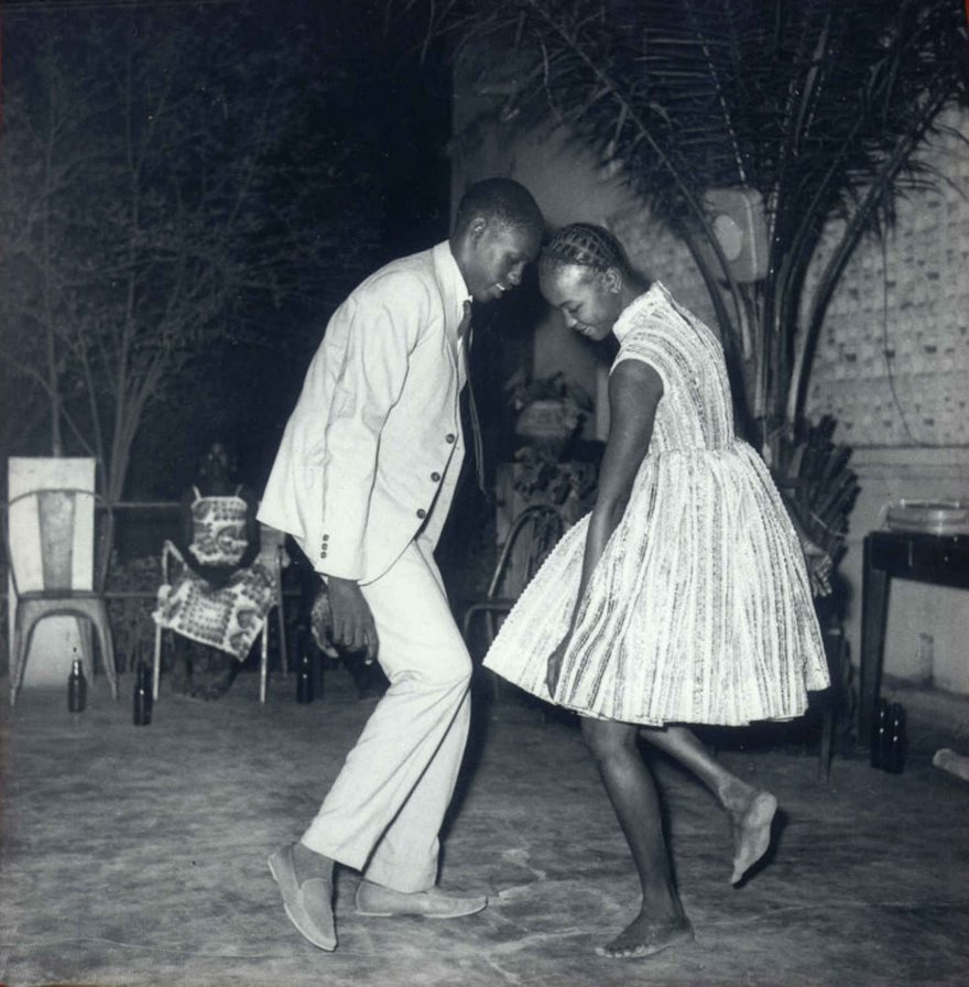 A couple dancing barefoot in a nostalgic black-and-white setting, capturing a famous moment in history.