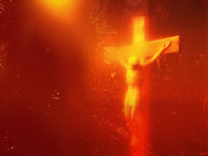 A glowing crucifix in orange light, representing one of the most famous photos in history.