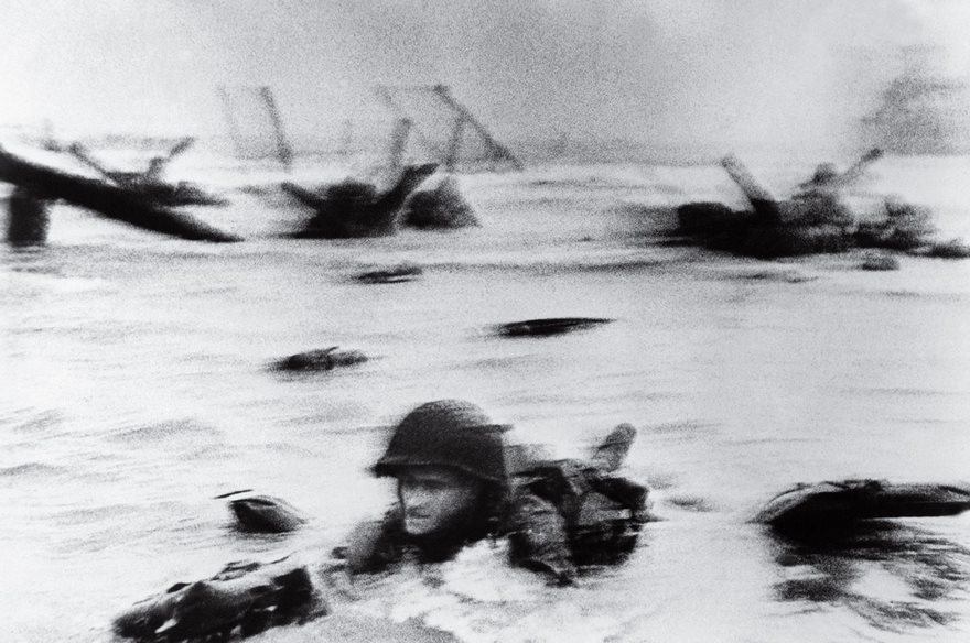 A soldier in water during a historic battle, capturing a famous moment in history with blurry background obstacles.