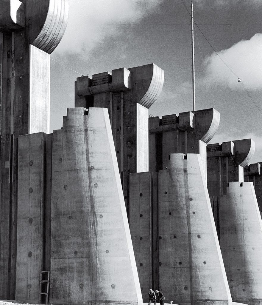 Massive concrete structures with unique tops against a cloudy sky, showcasing historical architecture in black and white photography.
