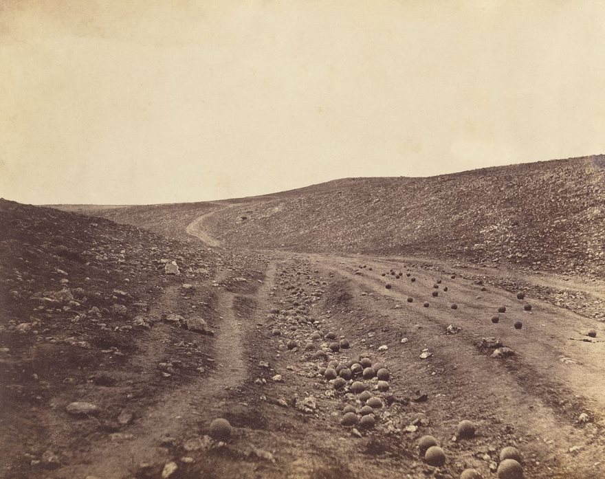 Historic photo of a barren battlefield landscape with scattered cannonballs, highlighting famous moments in history.