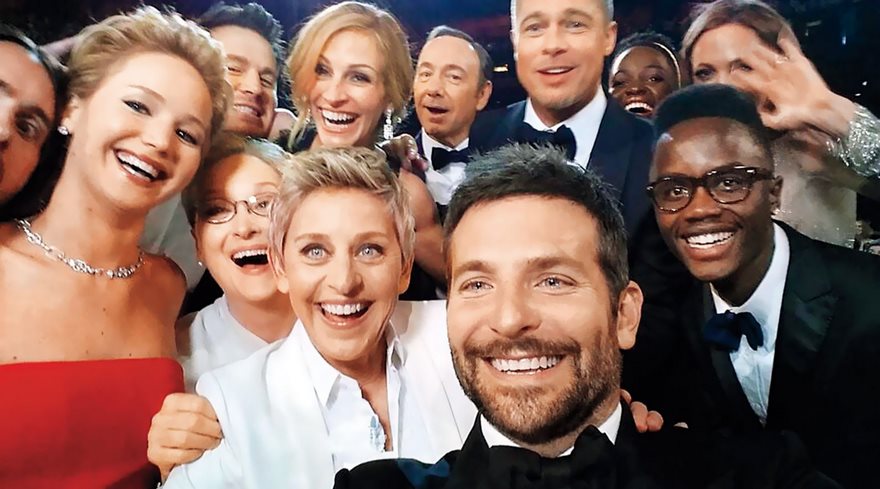 Group selfie at an awards event, featuring several smiling celebrities, capturing one of the most famous photos in history.