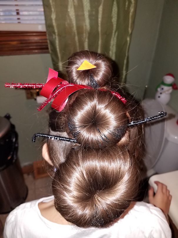 Creative Christmas hairstyle with festive decorations in brown hair buns.