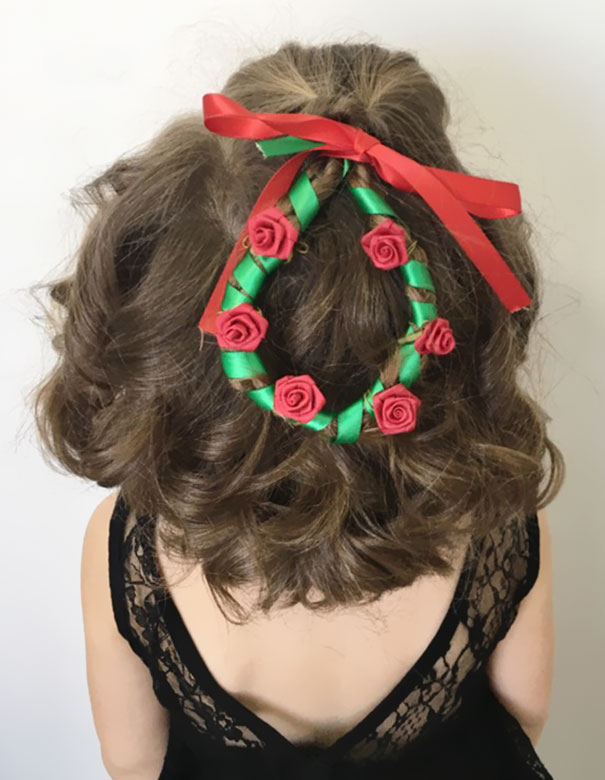 Creative Christmas hairstyle with a wreath made of green ribbon and red roses, topped with a red bow.