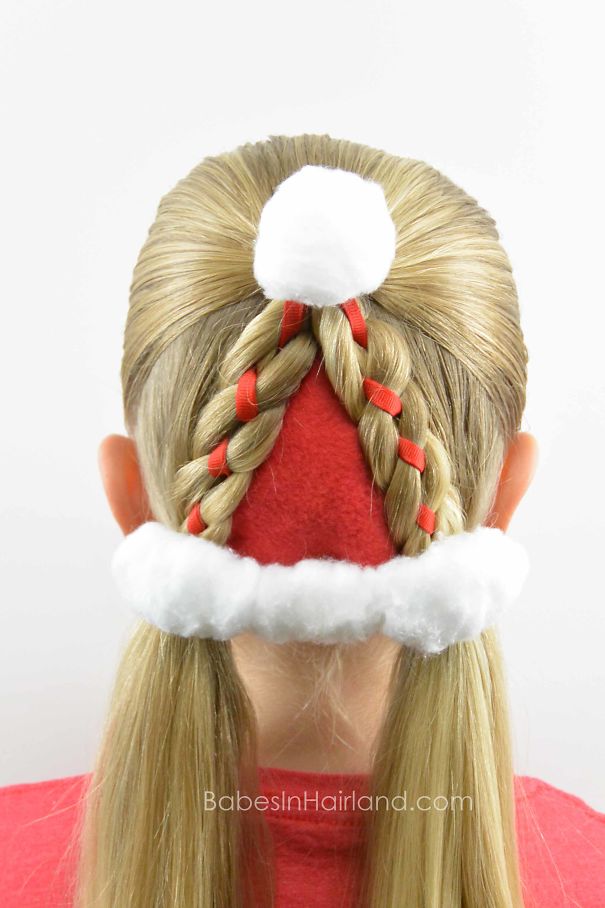 Creative Christmas hairstyle featuring braided hair styled like a Santa hat with red ribbons and white trim.