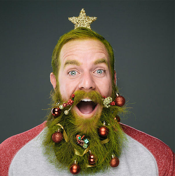 Man with a creative Christmas hairstyle, featuring green hair and beard decorated with ornaments and a golden star.