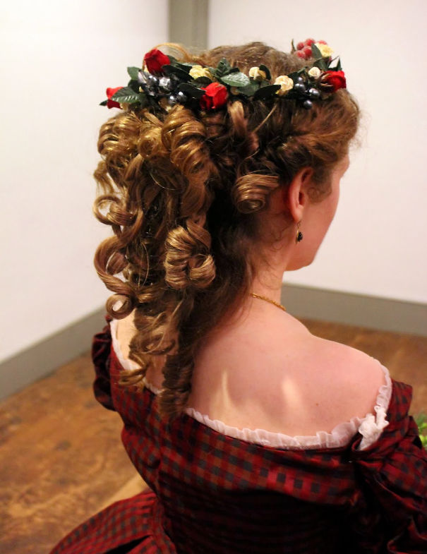 Creative Christmas hairstyle with curls and floral accents in a vintage setting.