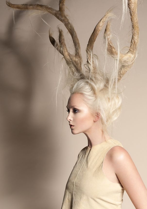 Creative Christmas hairstyle with antler-like design on a woman, highlighting unique holiday-themed hair artistry.