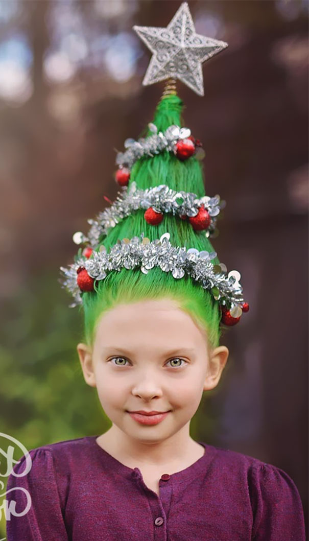 Child with a creative Christmas hairstyle, hair styled like a Christmas tree with ornaments and a star topper.