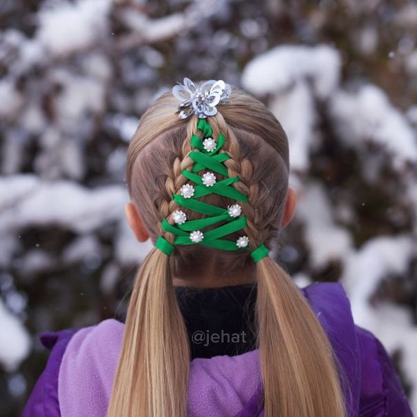 Creative Christmas hairstyle with braided hair decorated like a festive tree using green ribbon and flower clips.