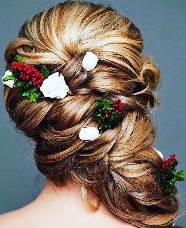 Creative Christmas hairstyle with braided blond hair adorned with red berries and white flowers.