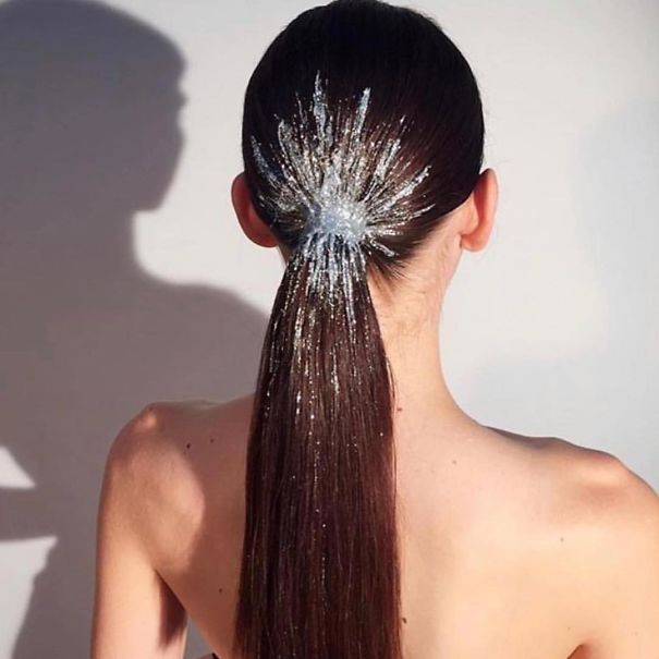 Creative Christmas hairstyle featuring dark hair with a sparkling, silver starburst design at the back.