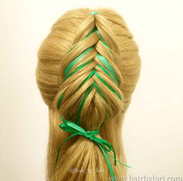 Creative Christmas hairstyle with a fishtail braid and green ribbon entwined, styled elegantly for the holiday season.