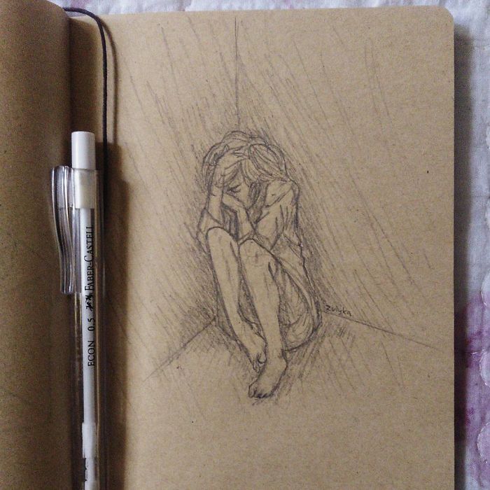 Sketch of a person sitting in a corner, illustrating depression, next to a mechanical pencil on a notebook page.