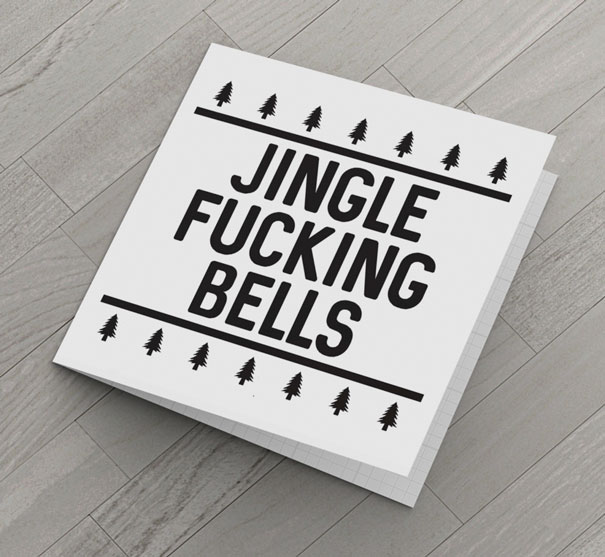 Rude Christmas card on a wooden floor with text "Jingle F*****g Bells" and tree decorations.