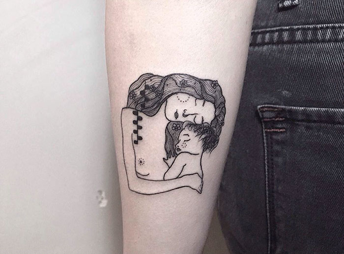 Gustav Klimt tattoo featuring a stylized mother and child on a person's forearm.