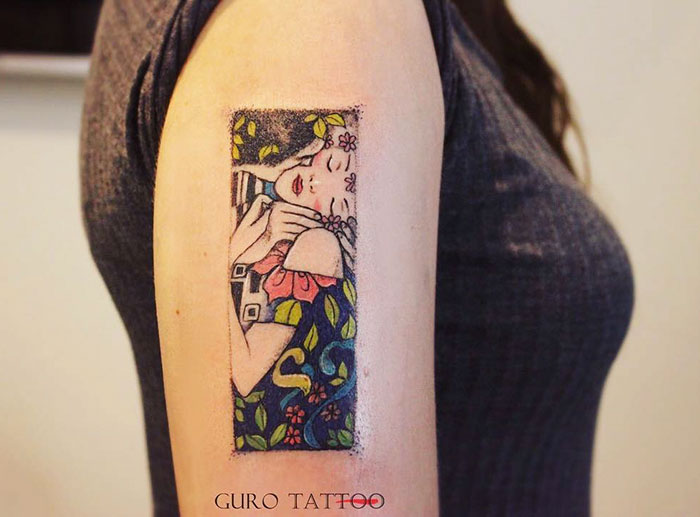 Gustav Klimt tattoo on upper arm depicting a colorful and intricate design.
